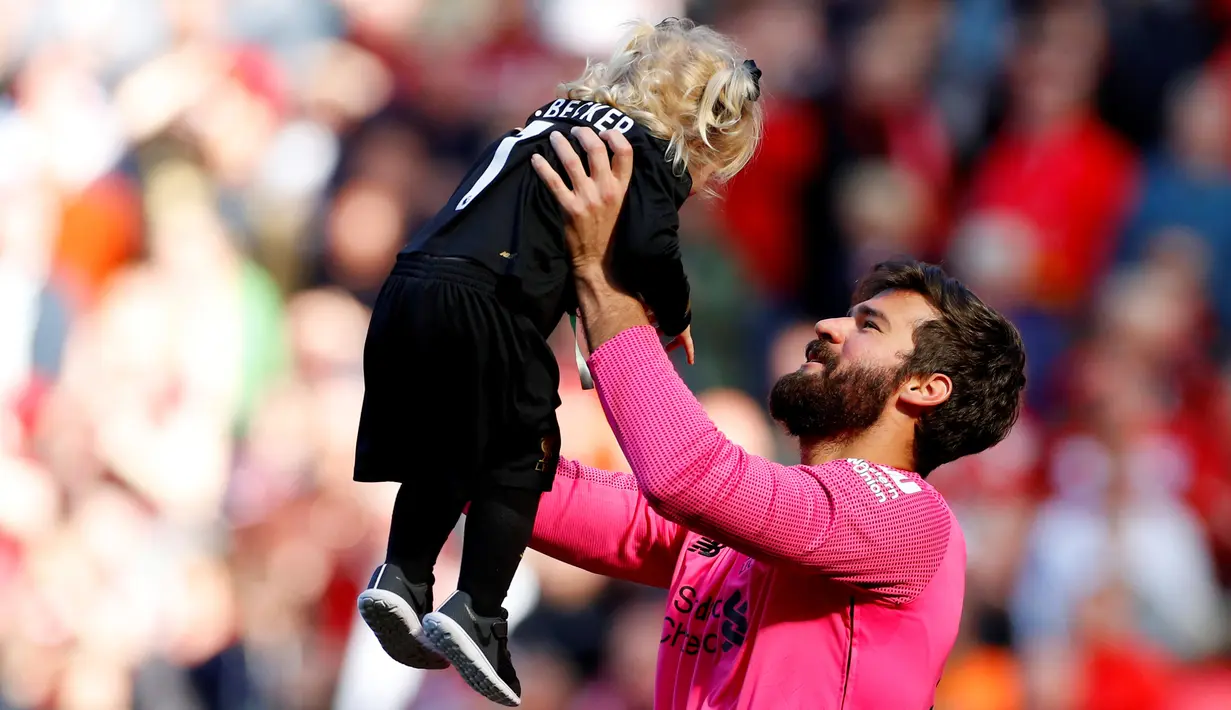 Kiper Liverpool, Alisson Becker, bermain dengan anaknya usai pertandingan melawan Wolverhampton Wanderers pada lanjutan Liga Inggris di Anfield, Inggris (12/5/2019). Liverpool gagal meraih gelar Liga Inggris walaupun berhasil mengalahkan Wolverhampton Wanderers 2-0. (AFP Photo/Phil Noble)
