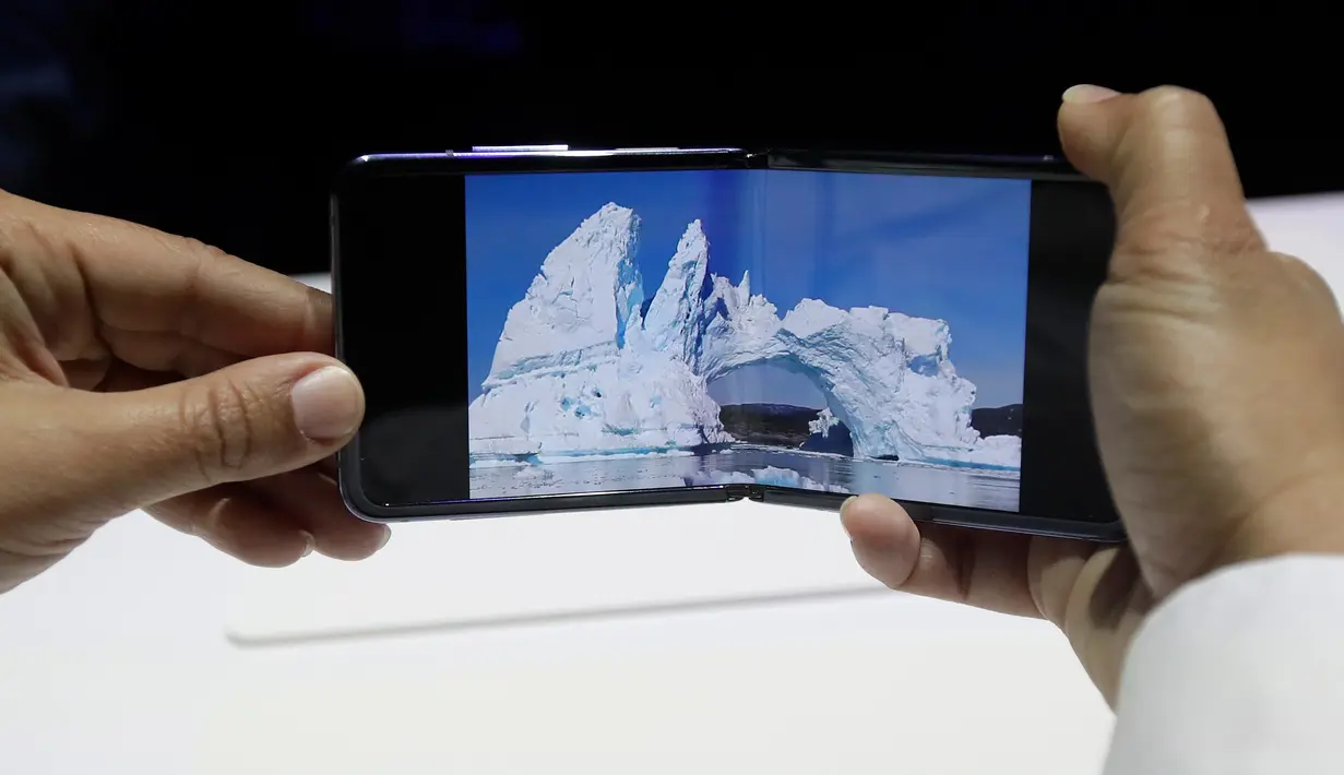 Seorang pekerja Samsung mendemonstrasi Galaxy Z Flip yang ditampilkan pada acara Unpacked 2020 di San Francisco, Selasa (11/2/2020). Untuk kamera, Galaxy Z Flip dibekali kamera 12MP dan kamera dengan sudut pandang lebar 123 derajat, serta kamera depan 10MP. (AP/Jeff Chiu)