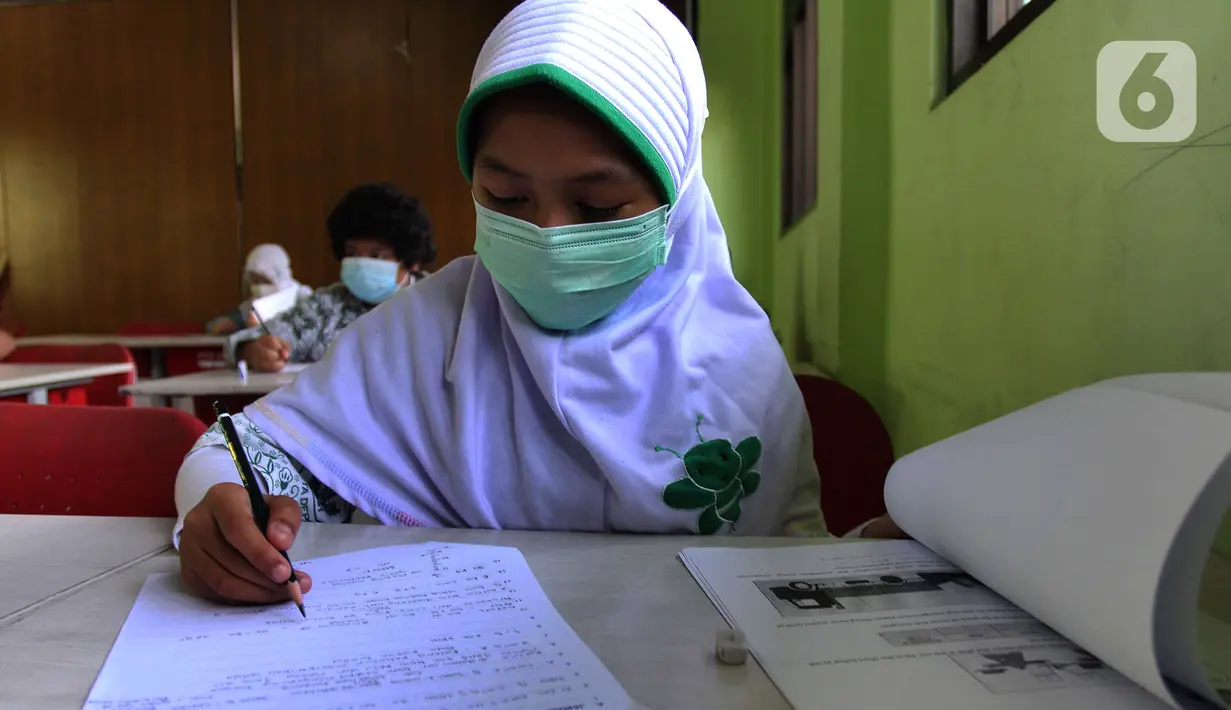Murid perwakilan sekolah mengerjakan soal saat kegiatan Kompetisi Sains Nasional (KSN) seleksi Tingkat SD/ MI se-Kota Depok mata pelajaran IPA di SDN Kemirimuka 3, Depok, jawa Barat, Senin (22/3/2021). Pelaksanaan KSN ini menerapkan protokol kesehatan. (merdeka.com/Arie Basuki)