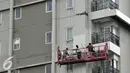 Sejumlah pekerja menyelesaikan pengecetan apartemen di kawasan Permata Hijau, Jakarta, Kamis (25/6/2015). Pemerintah menginstruksikan perusahaan untuk segera menerapkan Sistem Manajemen Keselamatan dan Kesehatan Kerja (SMK3). (Liputan6.com/Johan Tallo)