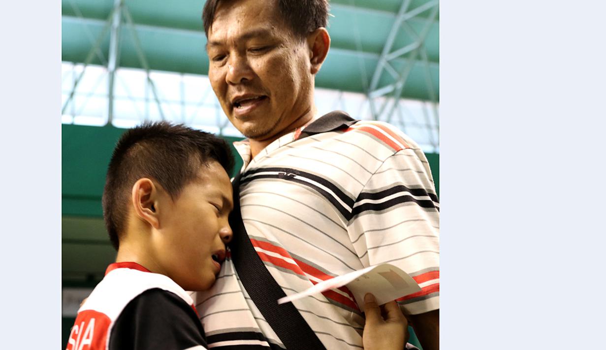 Emanuel Joseph Suryo Hartono, menangis di pelukan ayahnya setelah dinyatakan lolos masuk tahap karantina Audisi. (Bola.com/Arief Bagus)