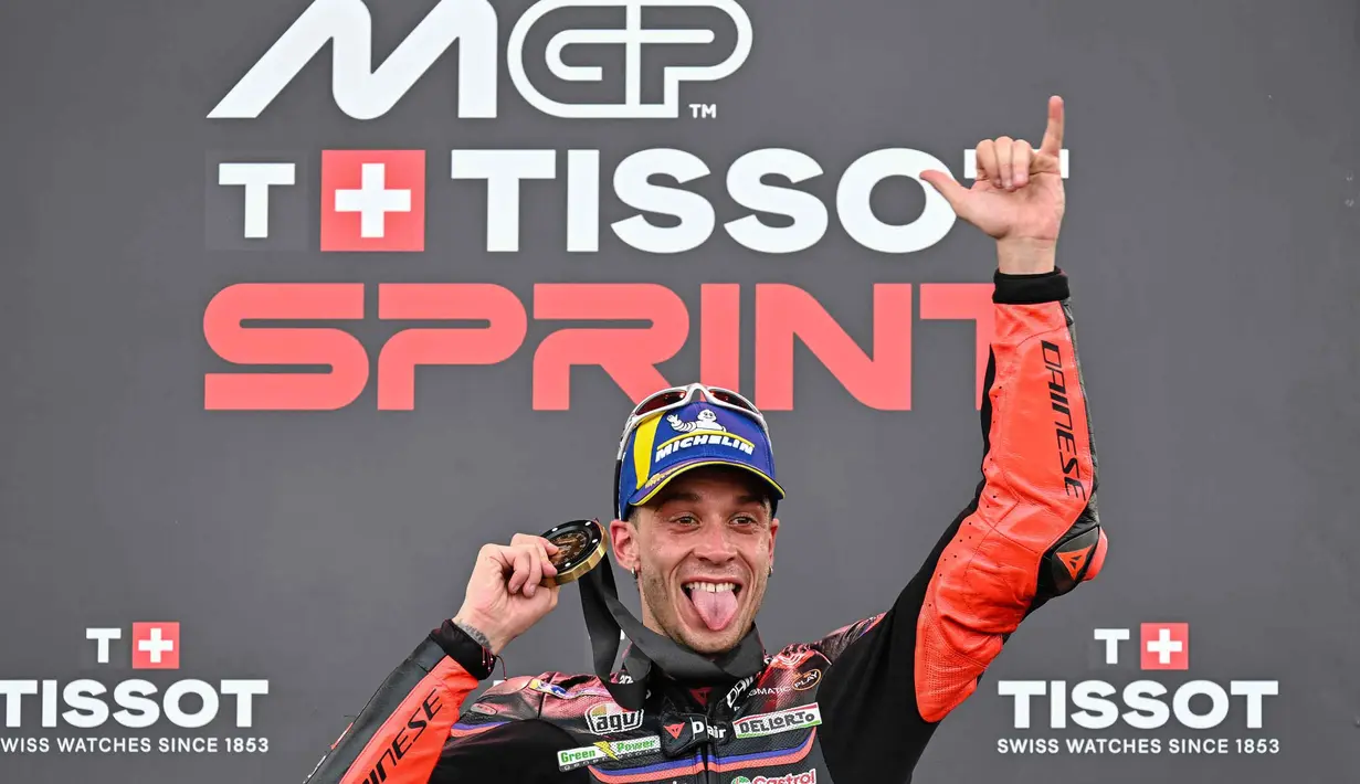 Pembalap MotoGP asal Italia dari tim Aprilia Racing, Marco Bezzecchi merayakan kemenangannya di podium setelah memenangkan Sprint Race pada MotoGP Grand Prix Indonesia di Sirkuit Internasional Mandalika, Nusa Tenggara Barat, pada Sabtu 4 Oktober 2025. (SONNY TUMBELAKA/AFP)