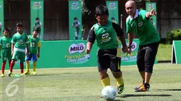 Pelatih sepak bola U-12 Zaenal Abidin sedang memberikan arahan mengenai cara menggiring bola kapada peserta MILO Football Clinic Day di Lapangan Sepakbola Pertamina-Simprug, Jakarta (29/10). (Liputan6.com/Istimewa)