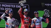 Pebalap Ducati Lenovo, Francesco Bagnaia (tengah) bersama Jorge Martin (kiri) dan Marc Marquez merayakan kemenangan usai balapan MotoGP Catalunya 2024, Minggu (26/4/2024). (LLUIS GENE/AFP)