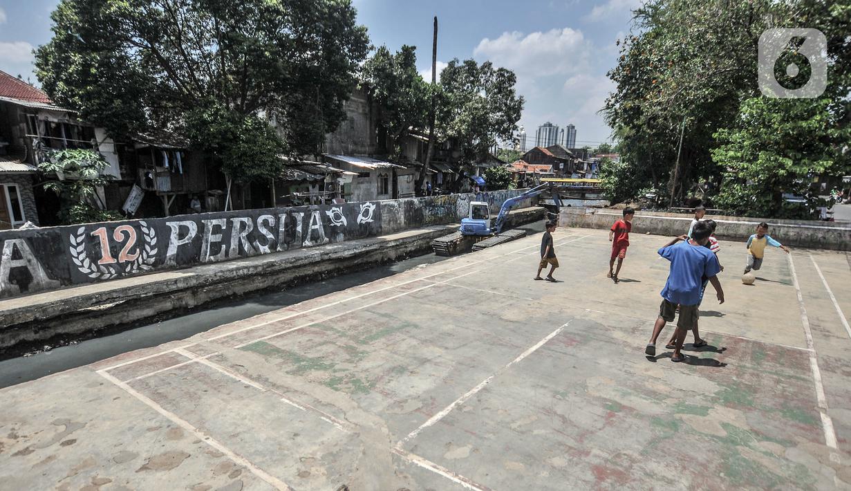 Anak-anak bermain di sekitar Kali Sentiong, Kecamatan Johar Baru, Rabu (22/9/2021). Pengerukan lumpur ini merupakan bagian dari program normalisasi guna memperdalam aliran Kali Sentiong. (merdeka.com/Iqbal S. Nugroho)