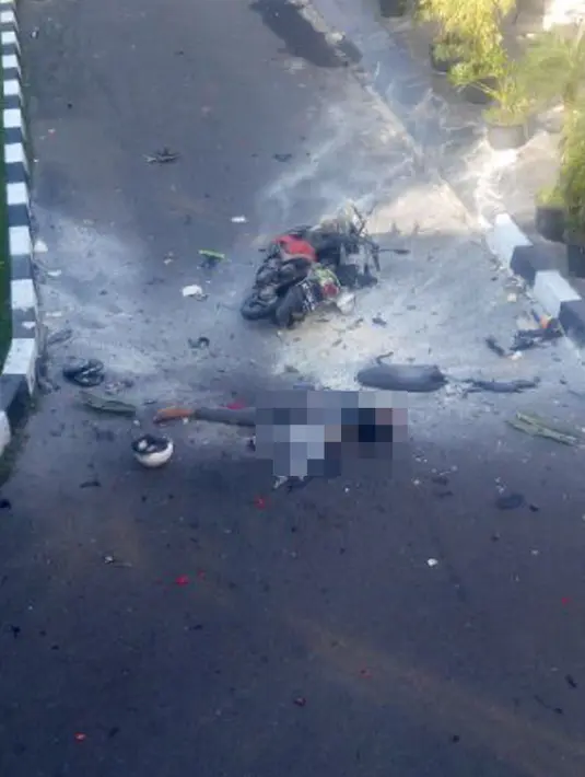 Seorang pria tergeletak di dekat sepeda motor dengan ceceran darah menyusul ledakan bom di halaman Polresta Surakarta, Solo, Jawa Tengah, Selasa (5/7). Bom diledakkan seorang pengendara motor yang berusaha menerobos masuk ke halaman Polresta. (Istimewa)