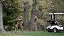 Penyidik memeriksa puing helikopter Blackhawk UH-60 milik Angkatan Darat AS yang jatuh di lapangan golf di Maryland Selatan, Senin (17/4). Seorang saksi mata lain mengatakan bahwa helikopter tersebut menabrak pohon saat jatuh. (AP Photo/Alex Brandon)