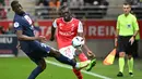 Bek Paris Saint-Germain (PSG) Nordi Mukiele (kiri) dan bek Reims Bradley Locko Banzouzi dalam pertandingan pekan ke-10 Liga Prancis di Stade Auguste-Delaune II, Minggu (9/10/2022) dini hari WIB. Baik PSG maupun Marseille mengistirahatkan pemain-pemain intinya guna menghadapi pertandingan Liga Champions tengah pekan depan. (DENIS CHARLET / AFP)