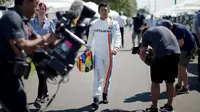 Manor Racing F1 driver Rio Haryanto walks to a drivers portrait session before the Australian Formula One Grand Prix in Melbourne. REUTERS/Jason Reed
