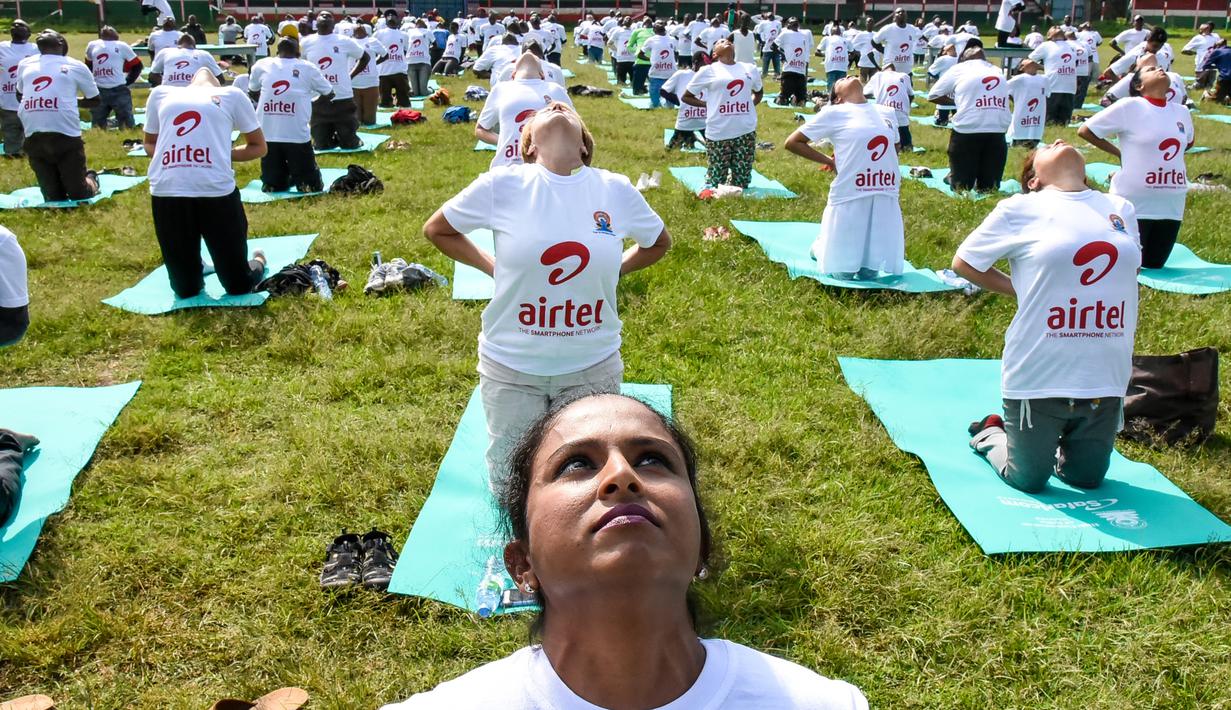 Ratusan warga melakukan gerakan yoga saat mengikuti sesi yoga massal di Stadion Afraha di Nakuru, Kenya (15/6/2019). Acara yoga massal ini untuk memperingati Hari Yoga Internasional. (AFP Photo/Suleiman Mbatiah)