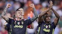 Para pemain Juventus, Federico Bernardeschi dan Alex Sandro merayakan kemenangan atas Valencia pada laga Liga Champions di Stadion Mestalla, Valencia, Rabu (19/9/2018). Juventus menang 2-0 atas Valencia. (AFP/Javier Soriano)