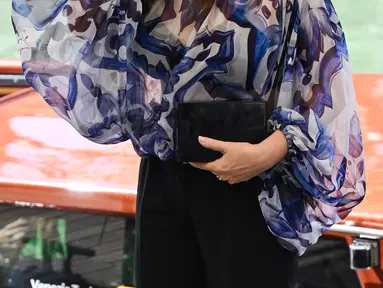 Monica Bellucci melambaikan tangan saat tiba di dermaga Palazzo del Cinema selama Venice Film Festival 2022 ke-79 di Lido di Venesia, Italia (8/9/2022). Monica Bellucci terlihat sangat chic dalam blus biru tipis dan celana hitam saat ia tiba di sesi pemotretan Siccita. (AFP/Andreas Solaro)