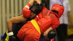 Atlet wushu Indonesia, Moria Manalu (kiri), membanting lawannya asal Turki, Nagihan Kalyoncu, di kelas Sanda Wanita 60 kg pada Kejuaraan Dunia Wushu 2015 di Istora Gelora Bung Karno, Senayan, Jakarta, Senin (16/11/2015). (Bola.com/Nicklas Hanoatubun)