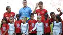 Pemain Bayern Muenchen Philipp Lahm, Manuel Neuer dan Thomas Mueller berfoto dengan anak-anak pengungsi (kaos merah) sebelum melawan FC Augsburg dalam lanjutan Liga Jerman. Sabtu (12/9/2015). (AFP Photo/DPA/Anandreas Gebert)
