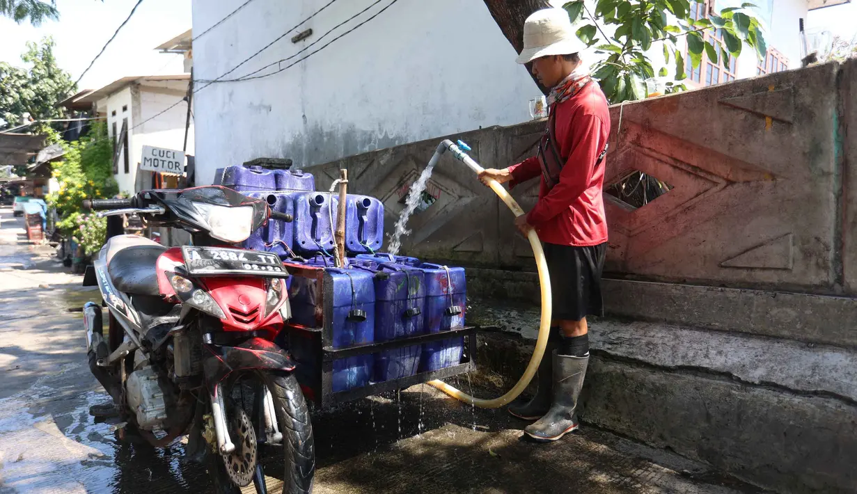 Pedagang mengisi jeriken dengan air bersih untuk segera didistribusikan kepada pelanggan di Kawasan Muara Angke, Jakarta, Kamis (28/5/2026). (Kapanlagi.com/Budy Santoso)
