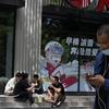 Warga makan di tangga sebuah restoran cepat saji yang tutup di Beijing, China, 15 Juni 2022. Otoritas China di Beijing menutup distrik perbelanjaan dan kehidupan malam utama menyusul lonjakan kasus COVID-19 terkait klub malam. (AP Photo/Ng Han Guan)
