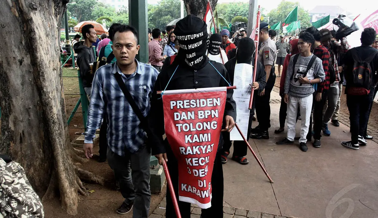 Aksi jalan kaki sambil menutup mata di depan Istana Negara, Jakarta, Selasa (18/11/2014). (Liputan6.com/Faizal Fanani)