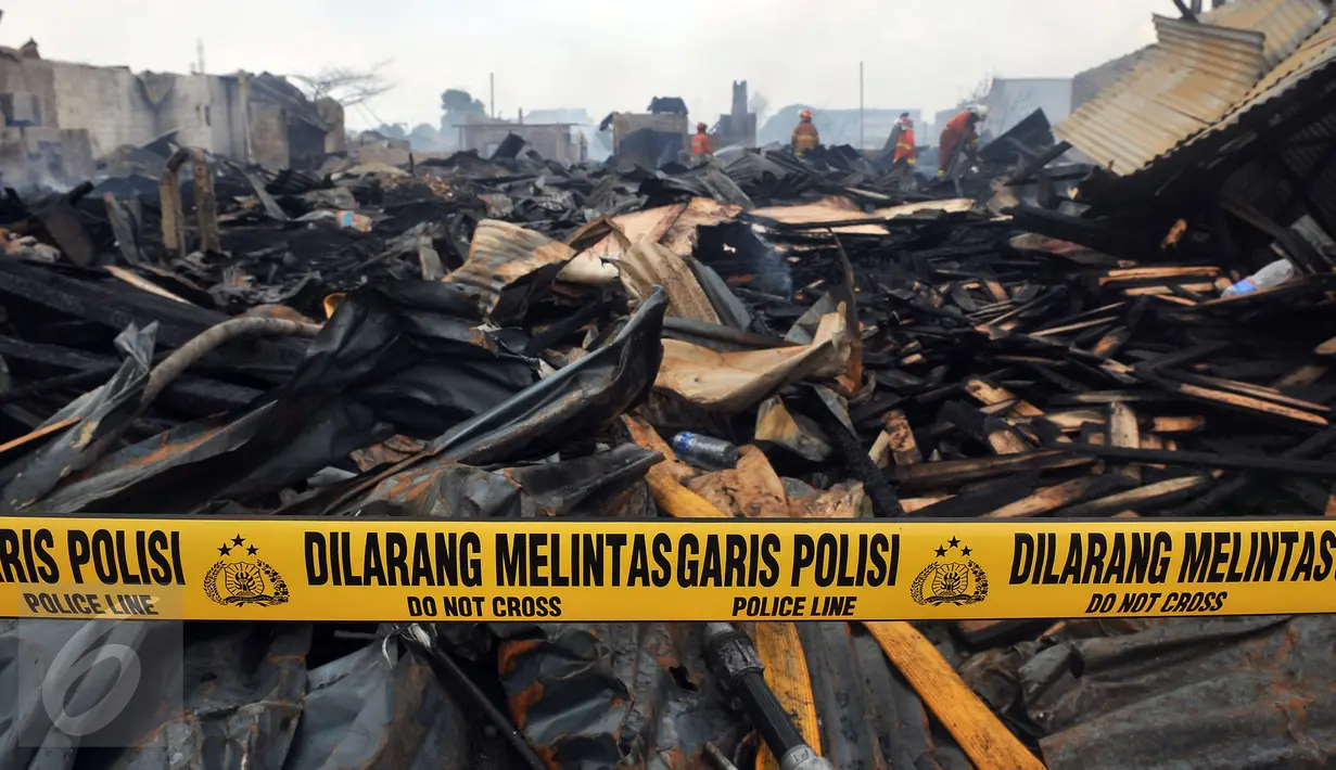Garis polisi terpasang di lokasi kebakaran yang melanda wilayah permukiman di Jalan Gotong Royong, RW 002 Pondok Bambu, Jakarta, Senin (8/8). Polisi masih mengusut penyebab kebakaran yang menghanguskan 90 rumah tersebut. (Liputan6.com/Johan Tallo)
