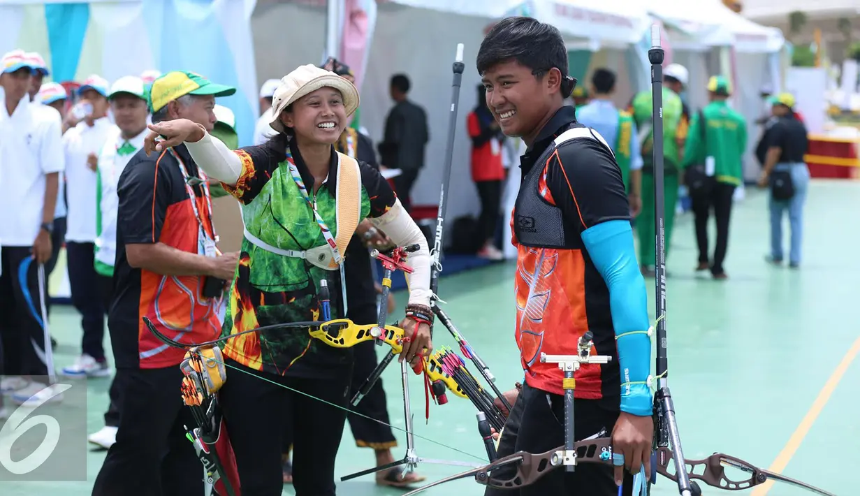 Pemanah Jatim, Eka Yuliana (tengah) berbincang dengan Riau Ega Agata S usai memastikan meraih emas di kelas Recurve Individual Putra Putri PON XIX Jabar di Lapangan Panahan Si Jalak Harupat, Kab Bandung, Rabu (21/9). (Liputan6.com/Helmi Fithriansyah)