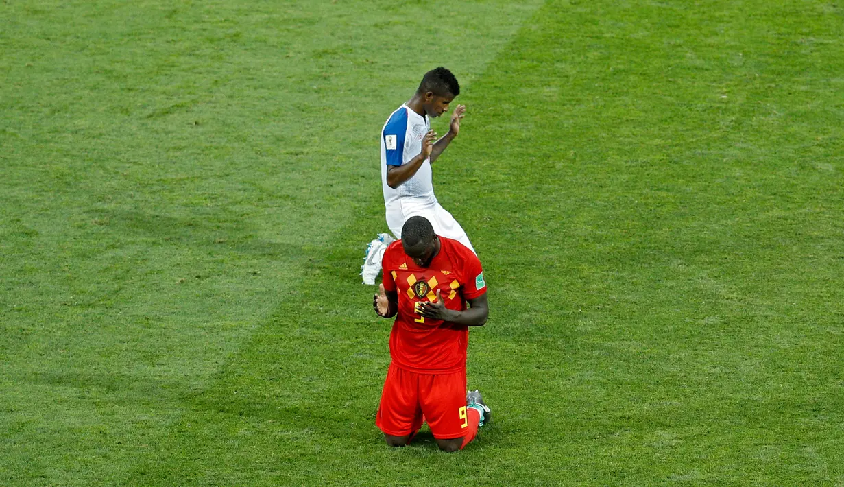 Pemain Belgia, Romelu Lukaku (bawah) dan Fidel Escobar dari Panama (atas) berdoa di akhir pertandingan Grup G Piala Dunia 2018 di Stadion Fisht, Sochi, Rusia, Senin (18/6). (AP Photo/Victor R. Caivano)