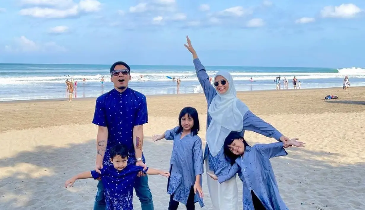 Natasha Rizki mengenakan kerudung putih, dipadukan kemeja panjang warna biru dan celana putihnya. [Instagram/@desta80s]