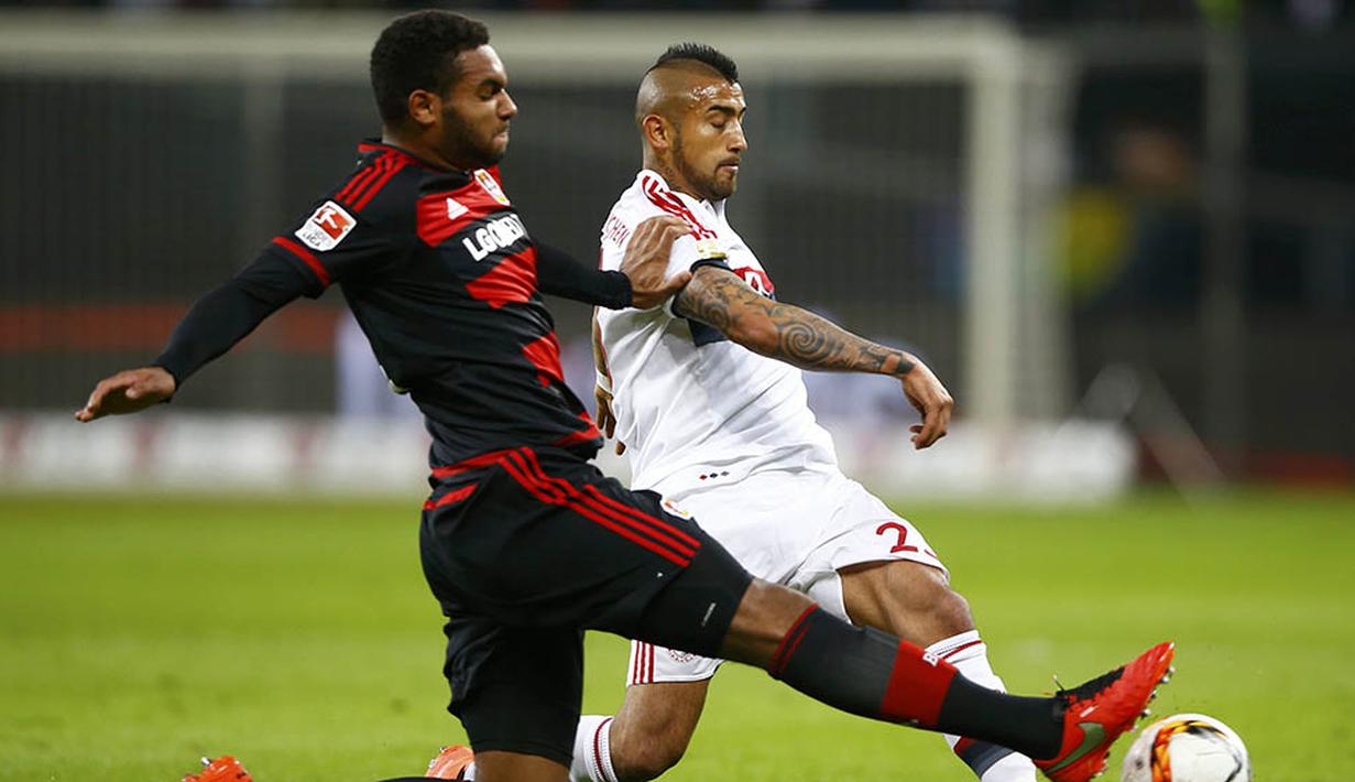 Gelandang bertahan Bayern Munchen, Arturo Vidal, berebut bola dengan bek Leverkusen, Jonathan Tah. Meskipun bermain tandang, Munchen lebih menguasai jalannya laga dengan penguasaan bola 59 persen. (Reuters/Wolfgang Rattay)