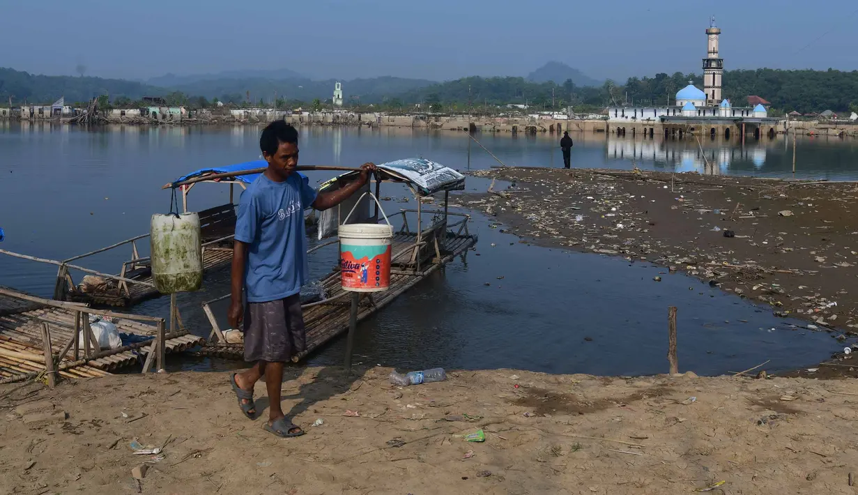 Warga memikul air yang diambil dari  kawasan Bendungan Karian yang mengering di Kampung Somang, Lebak, Banten, Jumat, 7 Agustus 2026. (KLY/ Arie Basuki)