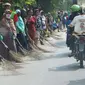 Sejumlah penyapu koin kali Sewo menunggu di sepanjang pinggir jalan, Subang, Jawa Barat, Sabtu (7/1). Mereka menunggu pengendara yang lewat melempar koin ke jalan. (Liputan6.com/Helmi Afandi)