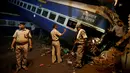Aparat kepolisian India berdiri dekat gerbong kereta Kalinga-Utkal Express yang tergelincir hingga keluar jalur di Negara Bagian Uttar Pradesh, Minggu (20/8). Hingga kini penyebab pasti terjadinya kecelakaan tersebut masih belum diketahui (AP/Altaf Qadri)