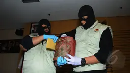 Dua orang penyidik KPK membawa kantong berisi uang suap yang diduga untuk anggota DPR Fraksi PDIP Adriansyah, Jakarta, Jumat (10/4/2015). KPK berhasil menangkap tangan pelaku saat bertransaksi di Bali.(Liputan6.com/Herman Zakharia) 