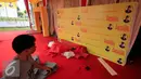 Seorang pekerja melintasi backdroup Ade Komarudin di kawasan alun alun utara Yogyakarta, Jumat (11/3/2016). Ade Komarudin akan mendekalrasikan pencalonan ketua Umum DPP Golkar yang akan bertarung pada Munaslub 2016. (Liputan6.com/Boy Harjanto)