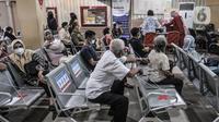 Warga lanjut usia (lansia) saat antre untuk mengikuti vaksin Covid-19 di Puskesmas Kecamatan Cilincing, Jakarta, Selasa (23/2/2021). Pemerintah mulai melakukan vaksinasi tahap dua yang diprioritaskan untuk masyarakat usia 60 tahun ke atas atau lansia. (merdeka.com/Iqbal S. Nugroho)