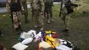Separatis Pro-Rusia melihat barang-barang milik penumpang MH17 yang berserakan, UKraina, Jumat (18/7/14). (REUTERS/Maxim Zmeyev)