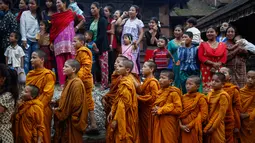 Sejumlah biksu cilik menyaksikan patung jerami Ghanta Karna yang dibakar di Bhaktapur di pinggiran Kathmandu, Nepal (21/7). Tradisi ini juga melambangkan musnahnya kejahatan di kota Bhaktapur. (AFP Photo/Uma Bista)