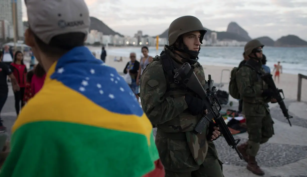 Tentara patroli di pantai Copacabana di Rio de Janeiro, Brasil, (30/7). Ribuan tentara mulai berpatroli di Rio de Janeiro di tengah lonjakan kekerasan di kota terbesar kedua di Brasil. (AP Photo / Leo Correa)