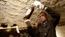 Pengurus kastil memeriksa botol anggur dari abad ke-19 yang disimpan dalam ruang bawah tanah di Kastil Becov di Becov nad Teplou, Republik Ceko, (22/5/2016).  (REUTERS/David W Cerny)