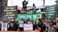 Para pengunjuk rasa menggelar aksi menentang rencana pemerintah untuk melepaskan kawasan hutan di Papua Selatan bagi proyek-proyek strategis nasional di bidang pangan, energi, dan pertahanan di depan Kantor Menteri Agraria dan Tata Ruang/Kepala Badan Pertanahan Nasional (ATR/BPN), Selasa (7/10/2025). (Yasuyoshi CHIBA/AFP)