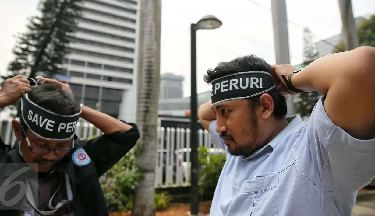 Massa Serikat Pekerja Peruri memasang ikat kepala bertuliskan "Save Peruri" saat berunjuk rasa di depan Kementerian BUMN, Jakarta, Selasa (19/1). Dalam aksinya, mereka menuntut direksi Perum Peruri untuk mundur . (Liputan6.com/Faizal Fanani)