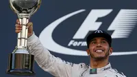 Pebalap Mercedes Lewis Hamilton mengangkat trofi usai memenangkan Formula 1 GP Jepang di Sirkuit Suzuka, Minggu (27/9/2015). (Liputan6.com/REUTERS/Thomas Peter)