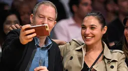 Aktris Gal Gadot berswafoto saat menyaksikan pertandingan NBA antara Los Angeles Lakers dan Los Angeles Clippers di Los Angeles, AS (19/10). Gal Gadot terlihat cantik dengan rambut dikuncir. (AP Photo / Mark J. Terrill)