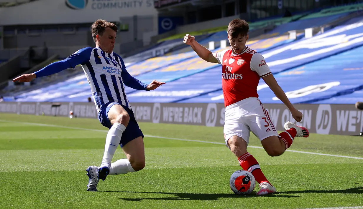 Pemain Brighton & Hove Albion, Solly March berusaha memblok tendangan bek Arsenal, Kieran Tierney pada lanjutan pertandingan Liga Inggris di The American Express Community Stadium, Sabtu (20/6/2020). Sempat unggul, Arsenal justru tumbang 1-2 di tangan Brighton. (Richard Heathcote/Pool via AP)