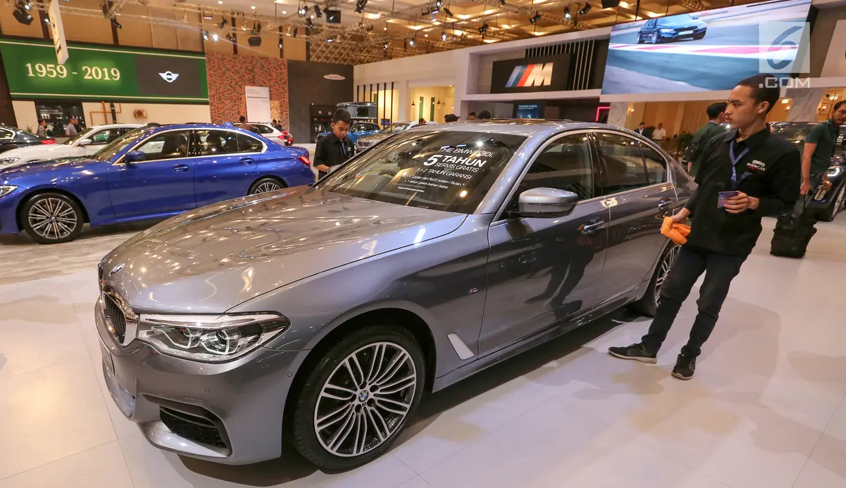 Pekerja membersihan mobil BMW 530i M Sport di pameran GIIAS 2019, di ICE BSD, Tangerang, Jumat (19/7/2019). Mobil yang masih diimpor atau dijual secara CBU (Completely Built Up) mesin 2,0 liter 4-silinder turbocharged yang bertenaga 255 PS. (Liputan6.com/Fery Pradolo)