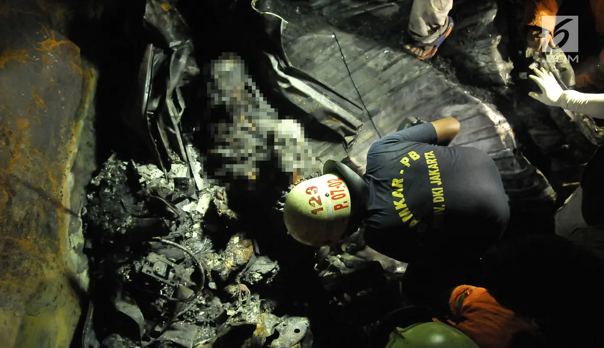 Petugas menemukan dua jasad yang sudah hangus terbakar di dalam puing minibus yang ringsek usai  kecelakaan kereta api di perlintasan Kramat, Senen, Jakarta, Selasa (13/6). (Liputan6.com/Helmi Afandi)