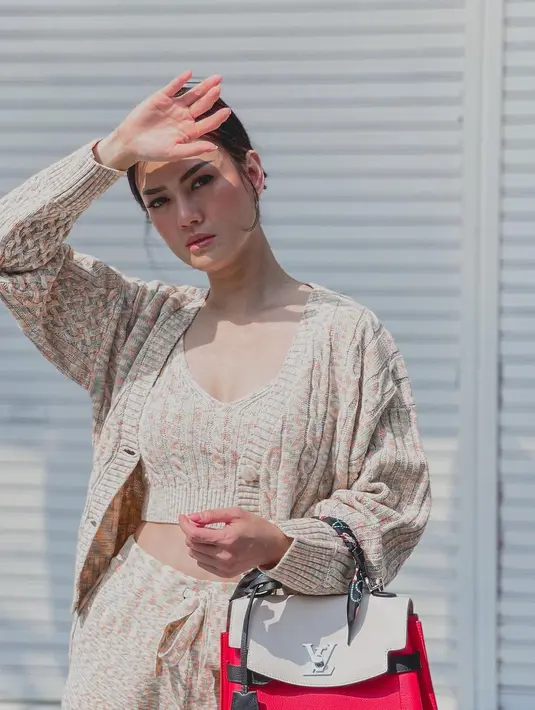 Nita Gunawan mengenakan knitted set berwarna nude yang terdiri dari croptop, jogger pants, dan cardigan. Set senada ini dipadukan dengan tas Louis Vuitton Lockme Bag dengan warna merah putih yang kontras seharga Ro52jutaan. (instagram/nitagunawan09)