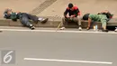 Massa aksi damai beristirahat di pinggir Jalan Merdeka Barat jelang bergerak menuju Istana Negara, Jakarta, Jumat (4/11). Massa melakukan aksi di depan Istana Negara menuntut penegakan hukum kasus dugaan penistaan agama. (Liputan6.com/Helmi Fithriansyah)