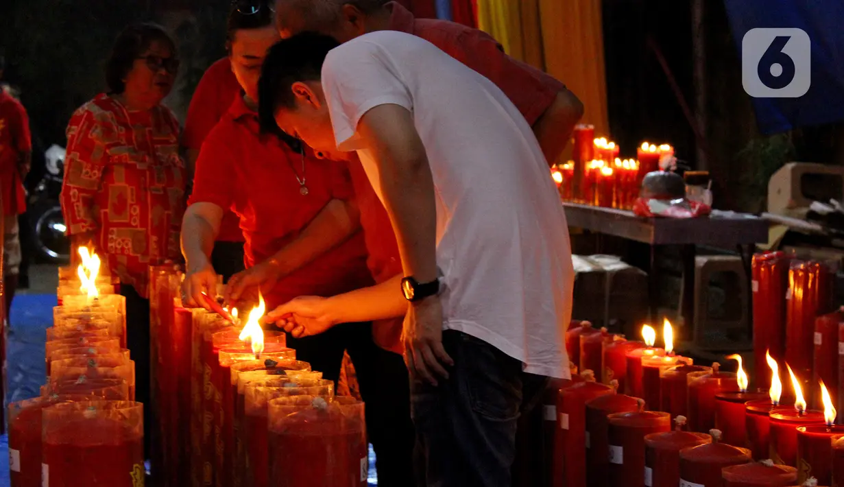 Warga keturunan Tionghoa menyalakan lilin saat melaksanakan sembahyang pada malam Tahun Baru Imlek 2571 di Vihara Dhanagun, Bogor, Jawa Barat, Jumat (24/1/2020). (merdeka.com/magang/Muhammad Fayyadh)