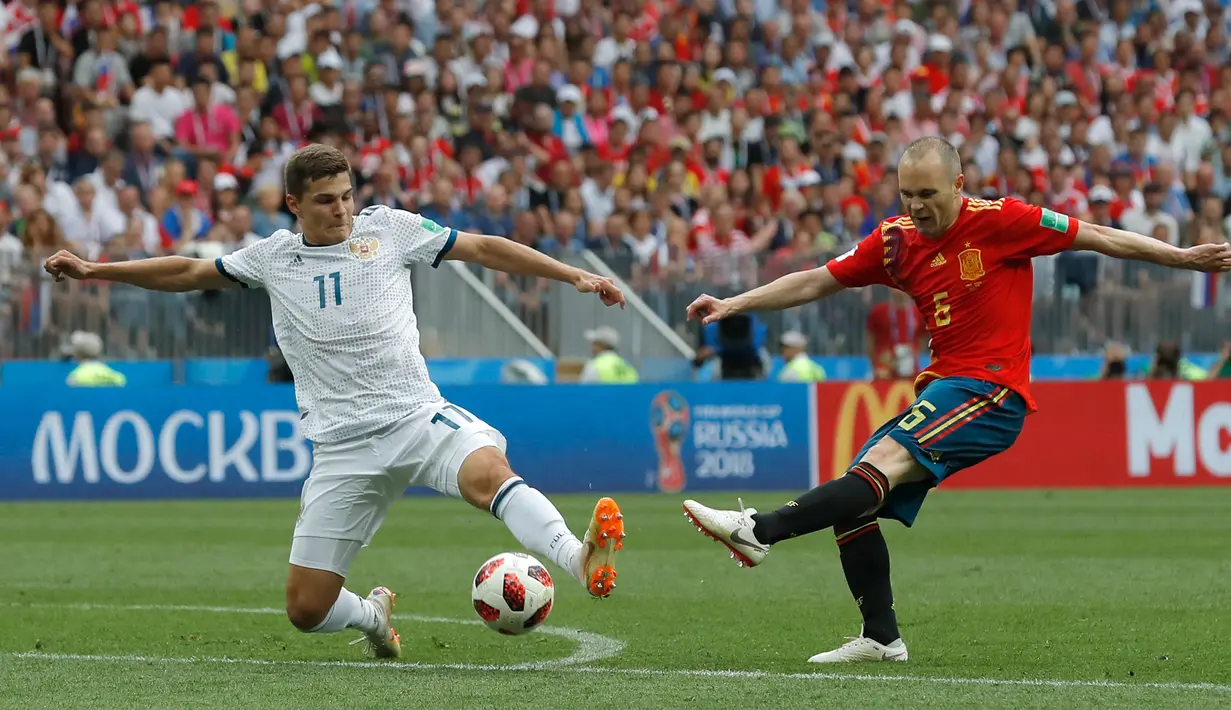 Pemain timnas Spanyol, Andres Iniesta, melakukan tendangan dengan dikawal pemain Ryusia, Roman Zobnin pada babak 16 besar Piala Dunia 2018 di Stadion Luzhniki, Minggu (1/7). Rusia lolos ke perempat final setelah menang adu penalti 4-3. (AP/Manu Fernandez)