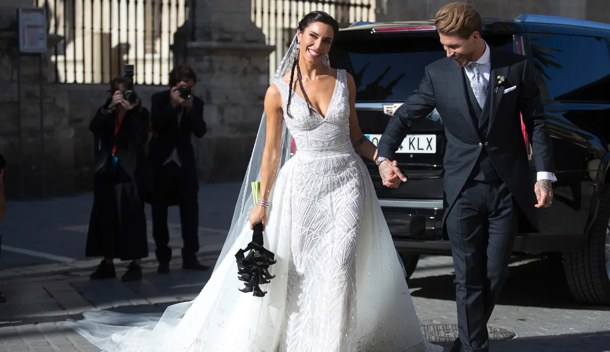 Bek Real Madrid, Sergio Ramos menggenggam tangan istrinya, Pilar Rubio setelah upacara pernikahan mereka di Sevilla, Spanyol (15/6/2019). Ramos resmi menikahi kekasihnya Pilar Rubio setelah berpacaran sejak 2012. (AP Photo/Antonio Pizarro)