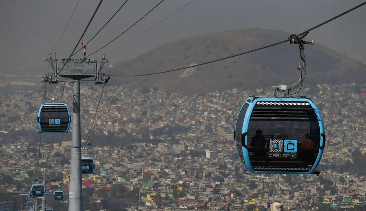 Pejabat dan jurnalis naik kereta gantung antara Stasiun Campos Revolucion dan Tlalpexco selama peresmian sistem angkutan umum udara baru yang disebut Cablebus di lingkungan Cuautepec, utara Mexico City, Meksiko, Kamis (4/3/2021). (AP Photo/Rebecca Blackwell)