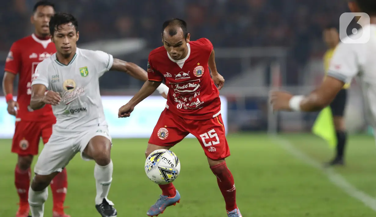 Gelandang sayap Persija, Riko Simanjuntak (kanan) berebut bola dengan pemain tengah Persebaya, Osvaldo Haay pada lanjutan Shopee Liga 1 Indonesia di Stadion Utama Gelora Bung Karno Jakarta, Selasa (17/12/2019). Persija kalah 1-2 dari Persebaya. (Liputan6.com/Helmi Fithriansyah)